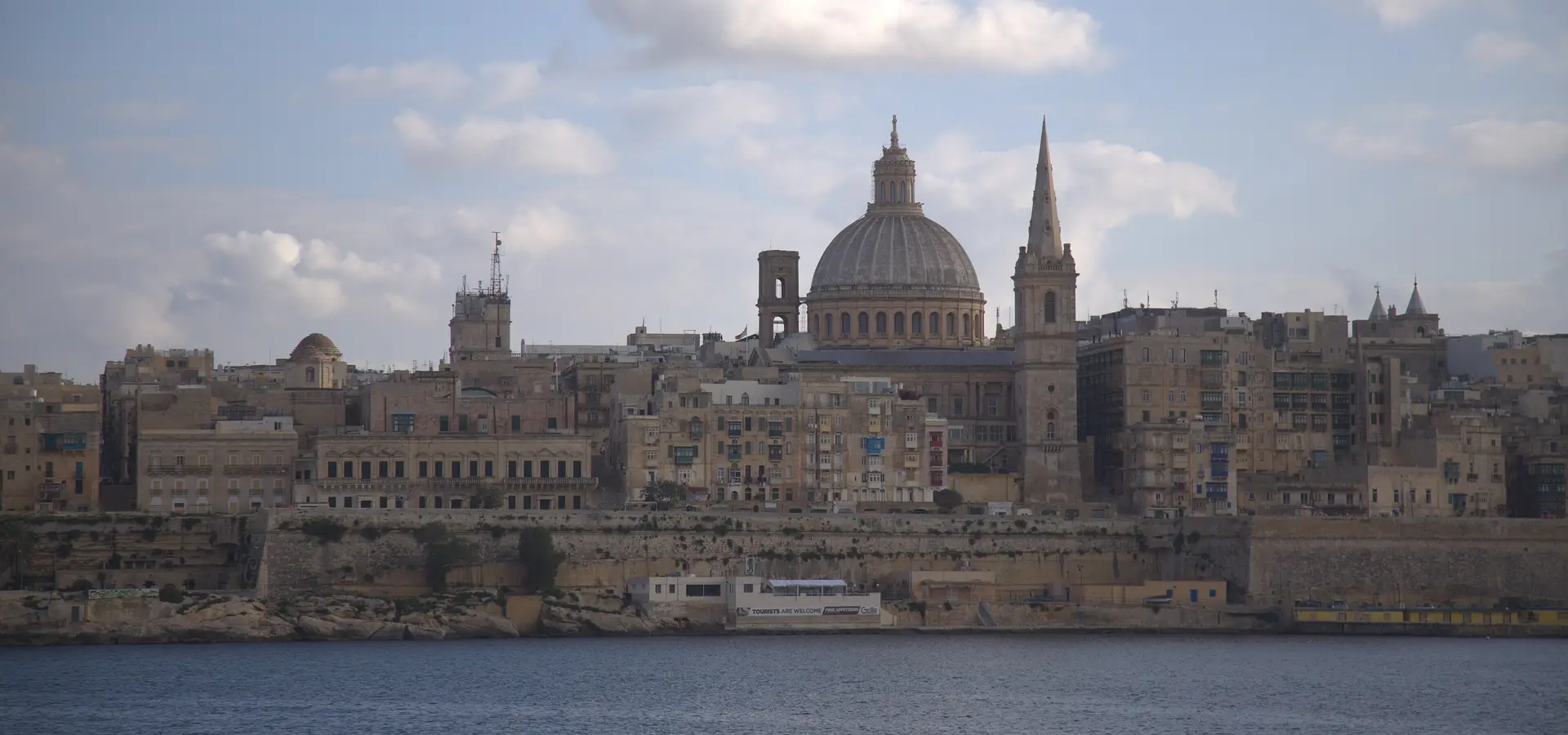 The domes and church spires of Valletta seen across Marsamxett Harbour from Sliema on a clear afternoon.